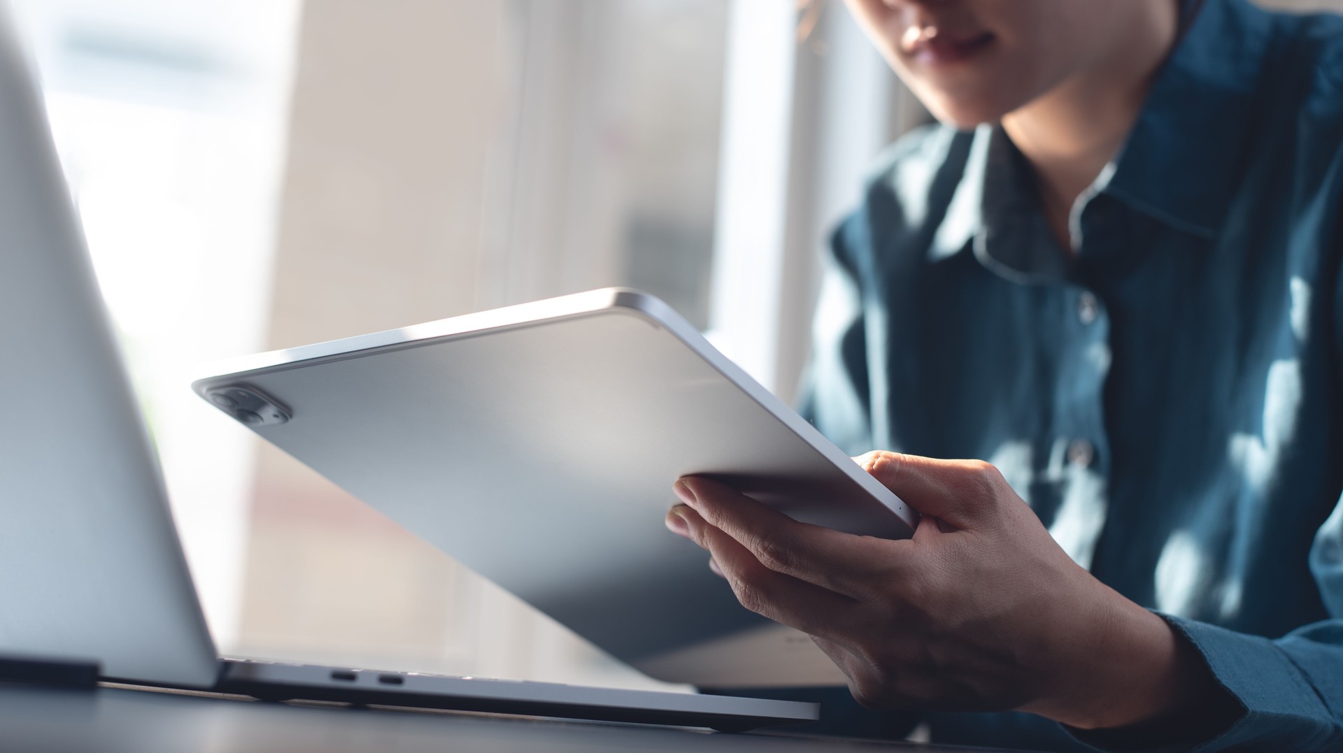 Young asian business woman using digital tablet and laptop computer, working at home office. Female student studying online via tablet and laptop computer, reading e-bbok via e-reader mobile app, internet technology